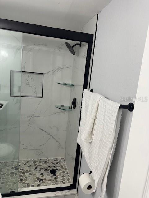 bathroom with a marble finish shower