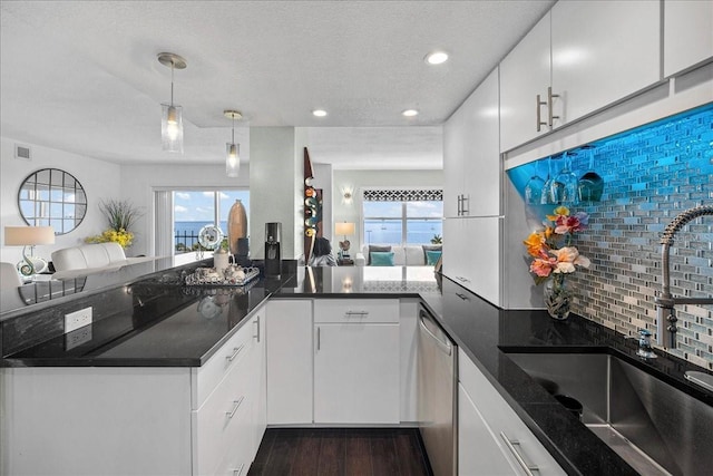 kitchen with stainless steel dishwasher, a sink, decorative backsplash, recessed lighting, and plenty of natural light