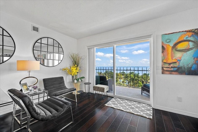 living area featuring wood finished floors, baseboards, and a water view