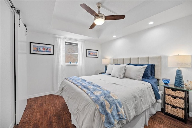 bedroom featuring wood finished floors, a barn door, baseboards, recessed lighting, and a ceiling fan