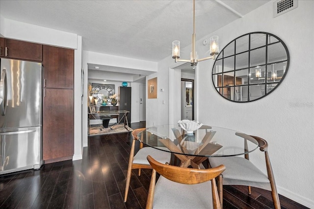 dining area featuring dark wood-type flooring, a chandelier, baseboards, and a textured ceiling