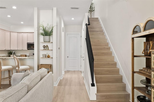 staircase with wood finished floors, recessed lighting, and baseboards
