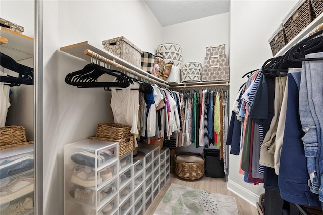 walk in closet with wood finished floors