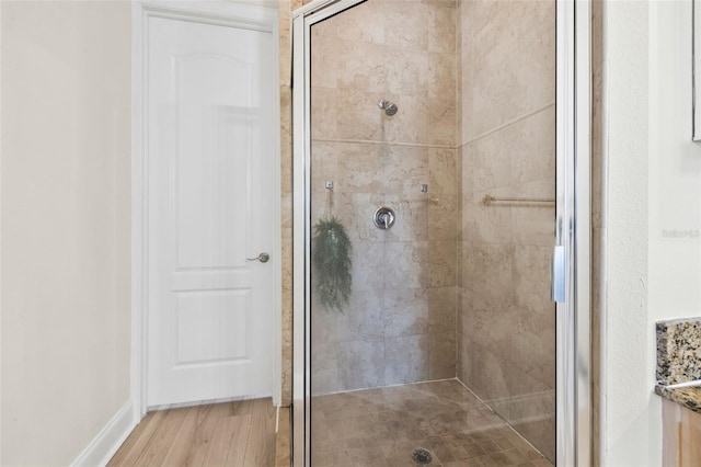 full bathroom featuring a shower stall and wood finished floors