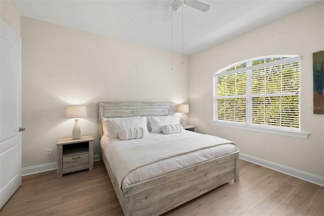 bedroom with baseboards, wood finished floors, and a ceiling fan