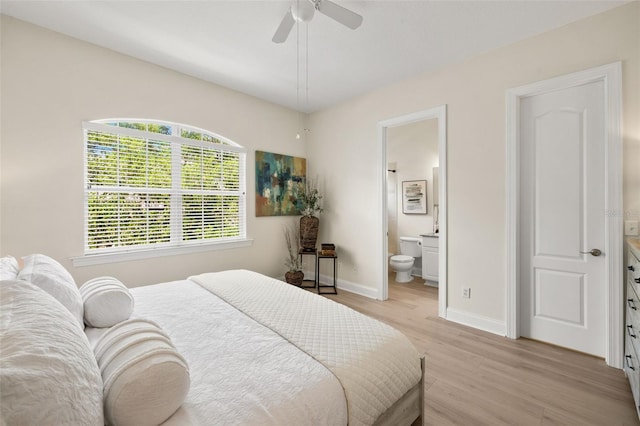 bedroom featuring light wood-style flooring, baseboards, ensuite bathroom, and ceiling fan