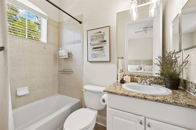 bathroom with ceiling fan, toilet, vanity, and tub / shower combination