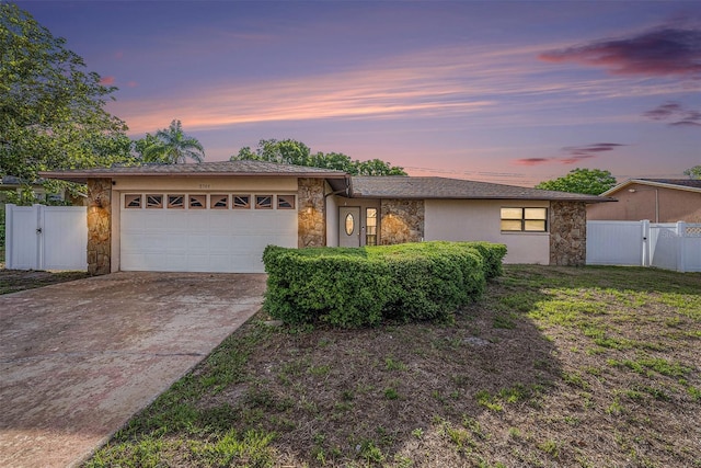 8744 Andros Ln, Port Richey, FL 34668 - view of front facade with stone siding, an attached garage, and a gate