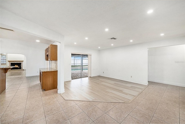 8744 Andros Ln, Port Richey, FL 34668 - unfurnished living room with light tile patterned floors, a fireplace, recessed lighting, and baseboards