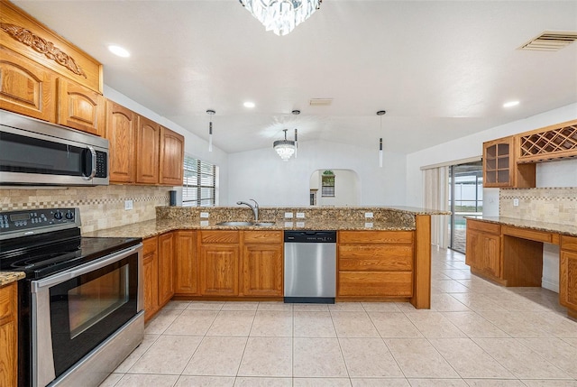 8744 Andros Ln, Port Richey, FL 34668 - kitchen featuring appliances with stainless steel finishes, a sink, tasteful backsplash, a peninsula, and vaulted ceiling