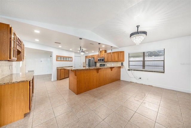 8744 Andros Ln, Port Richey, FL 34668 - kitchen featuring appliances with stainless steel finishes, brown cabinetry, light tile patterned floors, vaulted ceiling, and recessed lighting