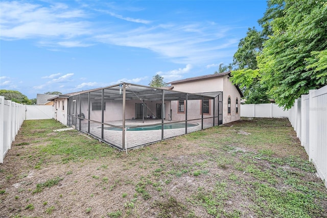 8744 Andros Ln, Port Richey, FL 34668 - back of house with glass enclosure, a patio, and stucco siding
