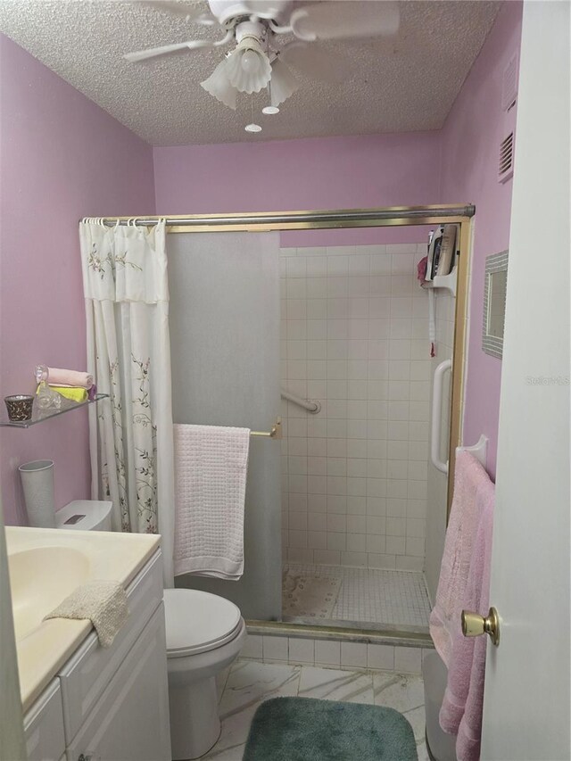 5705 80th St N Unit 303, Saint Petersburg, FL 33709 - full bathroom with a stall shower, toilet, vanity, a ceiling fan, and a textured ceiling