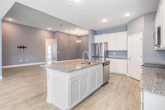12420 Brick Cobblestone Dr, Riverview, FL 33579 - kitchen with stainless steel appliances, a sink, light wood-type flooring, baseboards, and recessed lighting