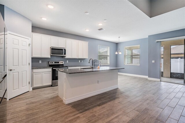 12420 Brick Cobblestone Dr, Riverview, FL 33579 - kitchen featuring appliances with stainless steel finishes, light wood-style floors, a sink, baseboards, and recessed lighting
