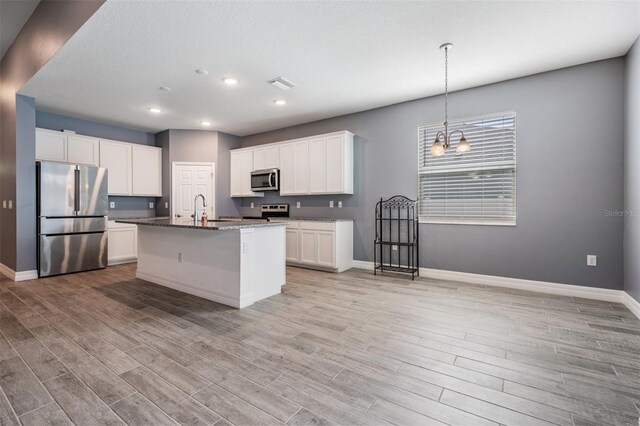 12420 Brick Cobblestone Dr, Riverview, FL 33579 - kitchen featuring appliances with stainless steel finishes, baseboards, light wood-type flooring, and recessed lighting