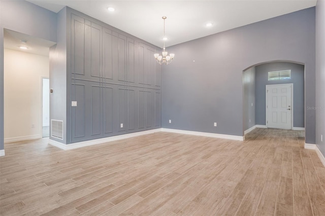 12420 Brick Cobblestone Dr, Riverview, FL 33579 - empty room with arched walkways, light wood-style floors, baseboards, a chandelier, and recessed lighting