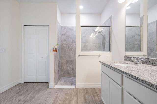 12420 Brick Cobblestone Dr, Riverview, FL 33579 - full bathroom featuring a walk in shower, vanity, wood finish floors, and baseboards