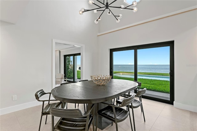 218 Colony Point Rd S, Saint Petersburg, FL 33705 - dining space with a chandelier, light tile patterned flooring, a towering ceiling, baseboards, and a water view