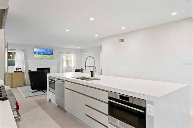 218 Colony Point Rd S, Saint Petersburg, FL 33705 - kitchen with a sink, appliances with stainless steel finishes, white cabinetry, open floor plan, and healthy amount of natural light