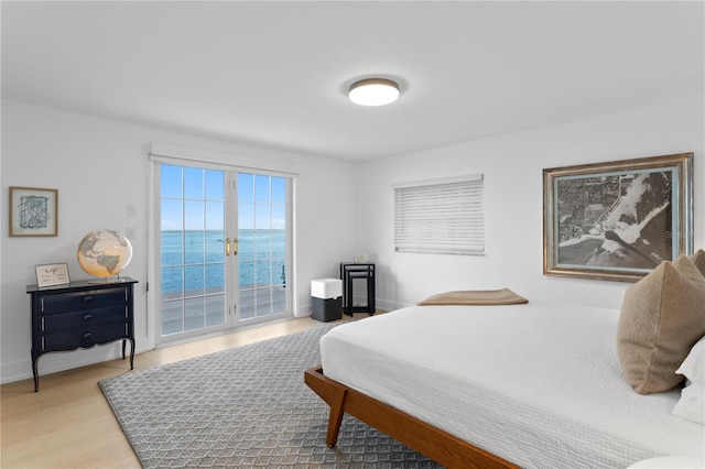218 Colony Point Rd S, Saint Petersburg, FL 33705 - bedroom with access to outside, light wood-style floors, french doors, baseboards, and a water view
