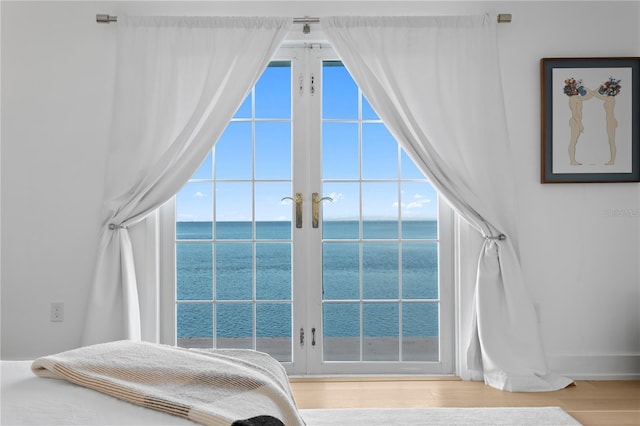 218 Colony Point Rd S, Saint Petersburg, FL 33705 - bedroom featuring french doors, a water view, wood finished floors, vaulted ceiling, and baseboards