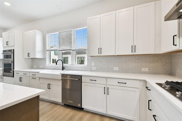 7240 Sutton Ln, Sarasota, FL 34240 - kitchen with appliances with stainless steel finishes, a sink, white cabinets, and light countertops