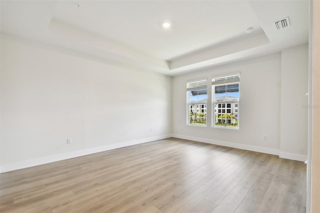 7240 Sutton Ln, Sarasota, FL 34240 - unfurnished room featuring a raised ceiling, light wood-style flooring, baseboards, and recessed lighting