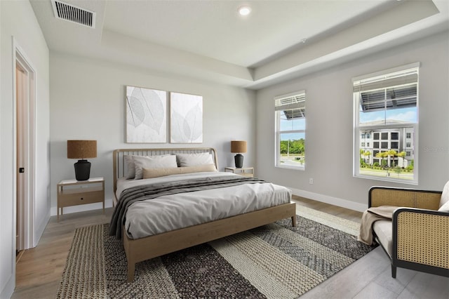 7240 Sutton Ln, Sarasota, FL 34240 - bedroom with a raised ceiling, baseboards, light wood-type flooring, and recessed lighting
