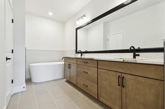7240 Sutton Ln, Sarasota, FL 34240 - full bathroom featuring tile patterned flooring, a freestanding bath, double vanity, recessed lighting, and a wainscoted wall