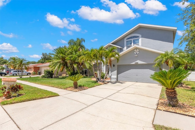 view of front of house with a front yard, driveway, an attached garage, and stucco siding