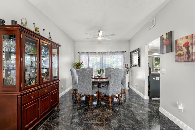 dining space with plenty of natural light, marble tiled floors, a ceiling fan, and baseboards