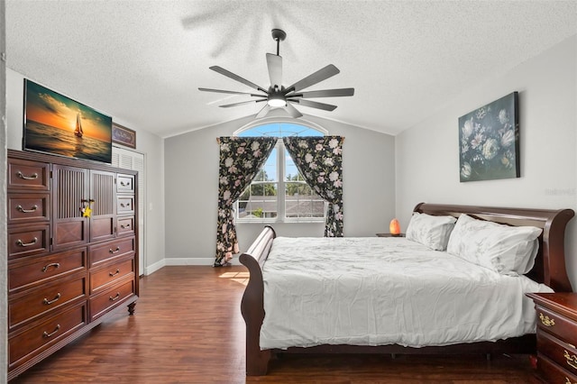 bedroom with lofted ceiling, dark wood-style flooring, a textured ceiling, baseboards, and ceiling fan