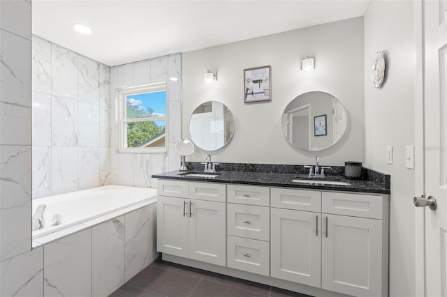bathroom with double vanity, a tub with marble appearance, and tile patterned flooring