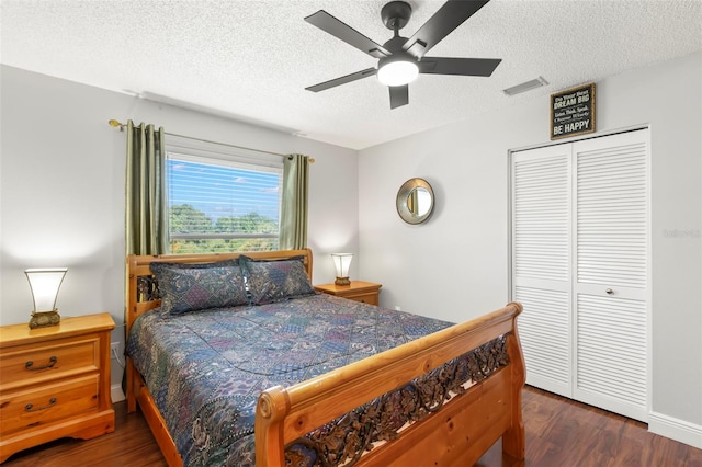 bedroom with a textured ceiling, wood finished floors, a closet, a ceiling fan, and baseboards