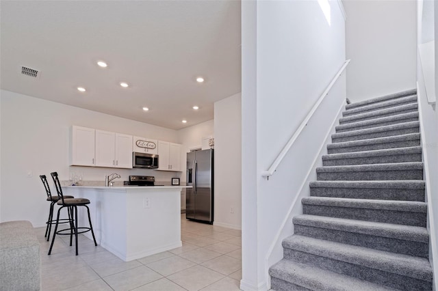 6542 95th Pl N, Pinellas Park, FL 33782 - kitchen with stainless steel appliances, a peninsula, white cabinets, recessed lighting, and a breakfast bar area