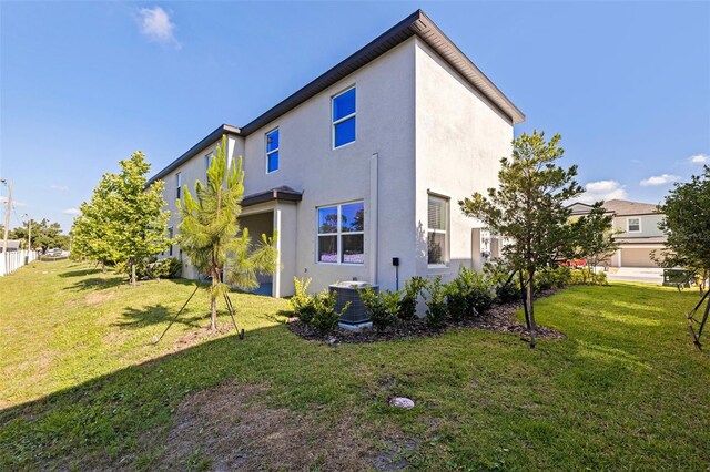 6542 95th Pl N, Pinellas Park, FL 33782 - back of house with stucco siding, central air condition unit, and a yard