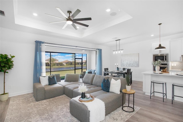 16117 Rosemallow Ln, Alva, FL 33920 - living room featuring light wood-style floors, a tray ceiling, recessed lighting, a ceiling fan, and crown molding