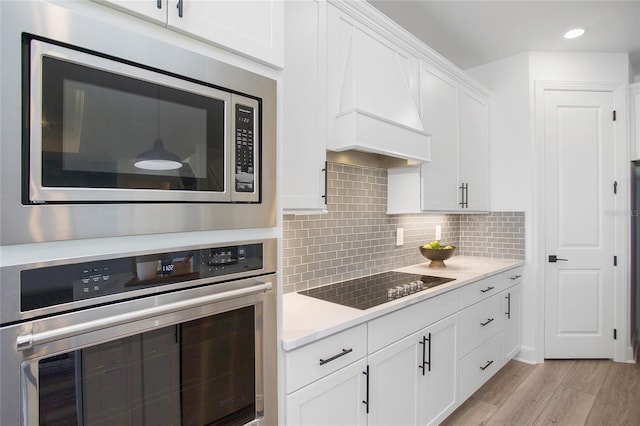 16117 Rosemallow Ln, Alva, FL 33920 - kitchen with appliances with stainless steel finishes, white cabinets, recessed lighting, light wood-style flooring, and decorative backsplash