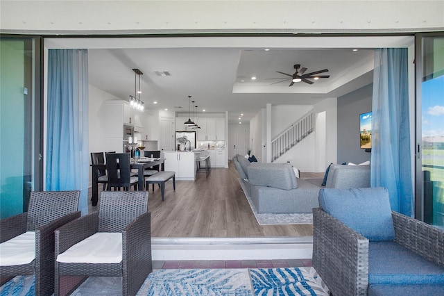 16117 Rosemallow Ln, Alva, FL 33920 - living room with stairway, a ceiling fan, light wood-type flooring, a tray ceiling, and recessed lighting