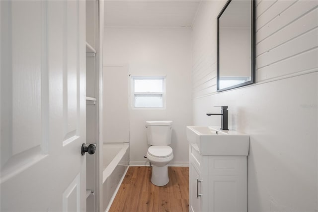 1527 E Lake Ave, Tampa, FL 33610 - bathroom featuring wood finished floors, toilet, vanity, a bathtub, and baseboards