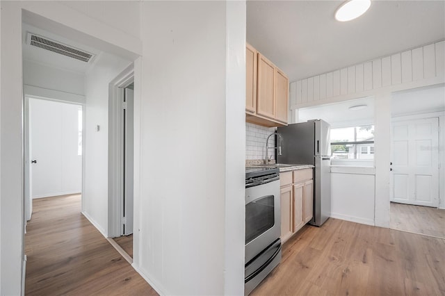 1527 E Lake Ave, Tampa, FL 33610 - kitchen featuring stainless steel appliances, a sink, light brown cabinets, and light wood finished floors
