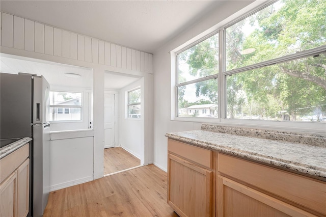 1527 E Lake Ave, Tampa, FL 33610 - kitchen featuring light wood-type flooring, freestanding refrigerator, light stone counters, and baseboards