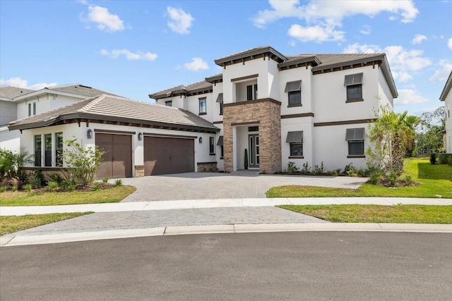 33750 Ocean Spray Ln, Wesley Chapel, FL 33543 - prairie-style home with stone siding, stucco siding, a garage, decorative driveway, and a tile roof
