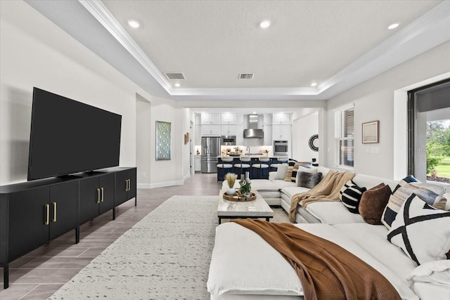 33750 Ocean Spray Ln, Wesley Chapel, FL 33543 - living area featuring a tray ceiling, crown molding, recessed lighting, light wood-style flooring, and baseboards