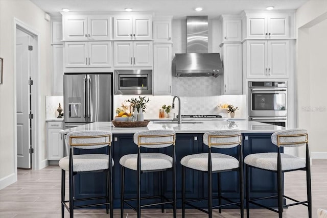 33750 Ocean Spray Ln, Wesley Chapel, FL 33543 - kitchen featuring wall chimney exhaust hood, appliances with stainless steel finishes, a sink, decorative backsplash, and white cabinetry