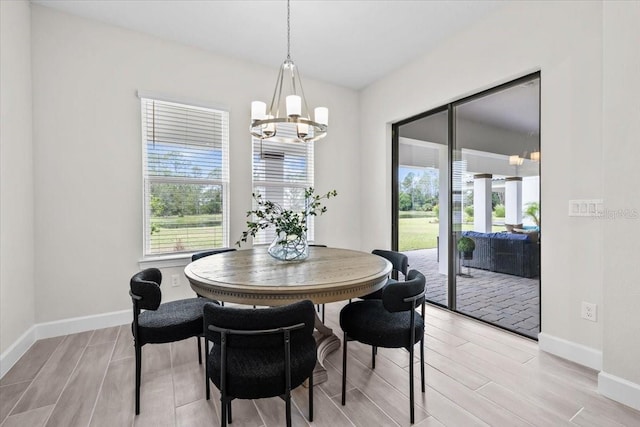 33750 Ocean Spray Ln, Wesley Chapel, FL 33543 - dining room featuring plenty of natural light, a chandelier, light wood finished floors, and baseboards