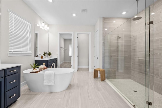 33750 Ocean Spray Ln, Wesley Chapel, FL 33543 - full bath with vanity, a shower stall, a soaking tub, a spacious closet, and recessed lighting