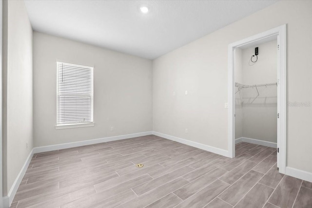 33750 Ocean Spray Ln, Wesley Chapel, FL 33543 - unfurnished bedroom featuring wood finished floors, baseboards, a closet, and a spacious closet