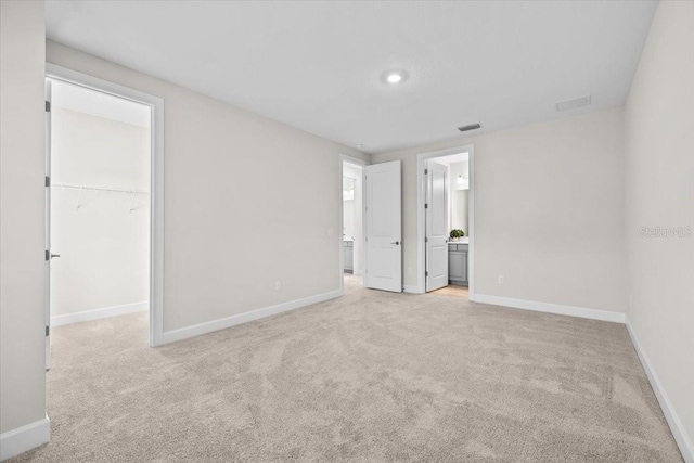 33750 Ocean Spray Ln, Wesley Chapel, FL 33543 - unfurnished bedroom with light colored carpet, a spacious closet, baseboards, and connected bathroom